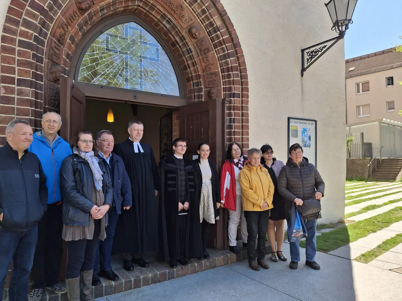 eine Gruppe von Menschen steht vor der Paul-Gerhardt-Kirche in Lübben